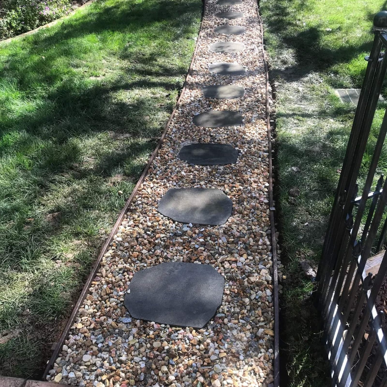 Beautiful garden pathway using stepping stones and gravel mulch for yard landscaping.
